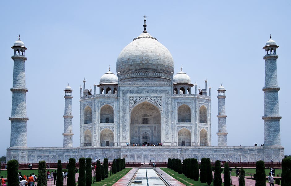 Front view of the iconic Taj Mahal in Agra, showcasing its magnificent architecture under a clear blue sky.